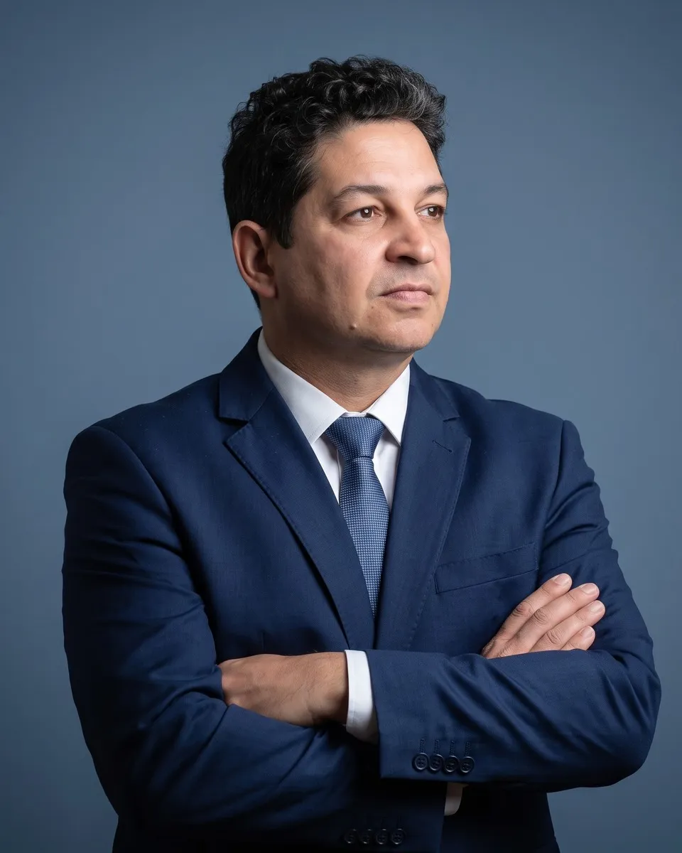 Dr. Carlos Fabiano de Oliveira, de terno azul e braços cruzados